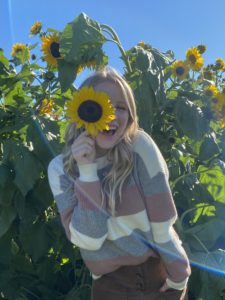 woman with sunflower over eye happy