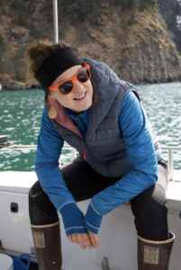 woman sitting on boat water smiling wearing blue